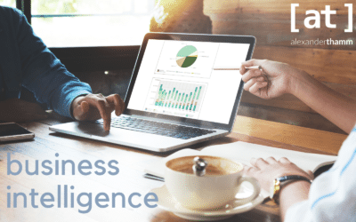 Business Intelligence illustration with laptop in a café - in the foreground a coffee cup and in the centre a data visualisation application on the laptop monitor - the logo of Alexander Thamm GmbH in the upper right corner.